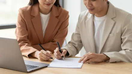 Deux professionnels relisent et signent ensemble une convention de formation sur un bureau lumineux