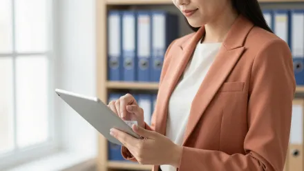 Responsable qualité d'un organisme de formation passant en revue une grille d'indicateurs Qualiopi sur une tablette